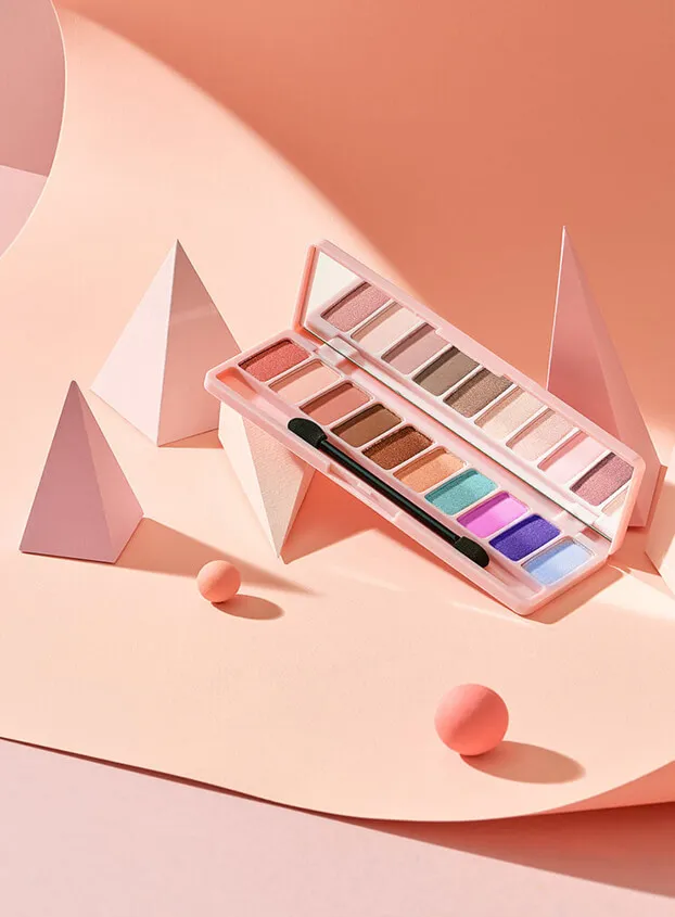 A colorful eyeshadow palette displayed in a modern, geometric setting, an example of product design for makeup brands.