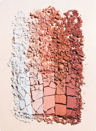 A beautiful texture shot of various crushed cosmetic face powders in nude and blush tones, perfect for makeup branding.