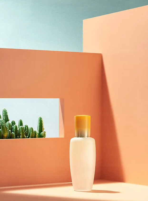 A minimalist skincare bottle with a yellow cap, staged in a desert-themed setting with cacti, perfect for natural or plant-based skincare branding.